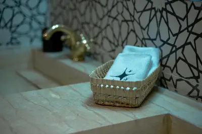 a basket with a towel on a counter next to a sink at Riad Nejma Benyoussef in Marrakech