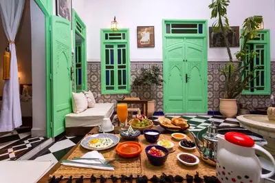 a room with green doors and a table with food at Riad Rose Meryam in Marrakech