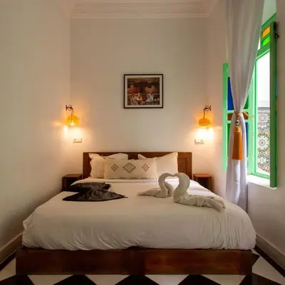 a bedroom with a bed with two birds on it at Riad Rose Meryam in Marrakech