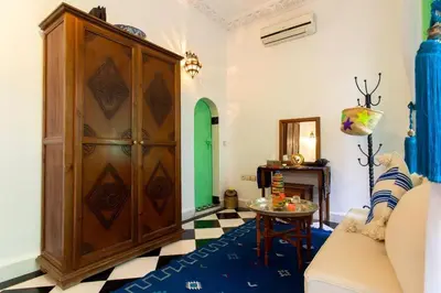 a living room with a large wooden cabinet and a table at Riad Rose Meryam in Marrakech