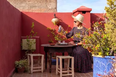 a woman standing next to a table with plants at Riad Rose Meryam in Marrakech