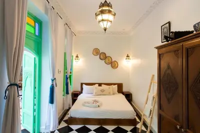 a bedroom with a bed and a chandelier at Riad Rose Meryam in Marrakech