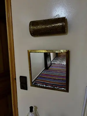 a mirror hanging on a wall with a rug at Dar Kawtar in Marrakech