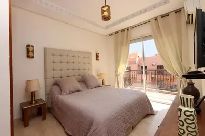 a bedroom with a bed and a large window at Apartment in the Heart of Marrakech 5th Floor in Marrakech