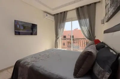 a bedroom with a bed and a large window at Apartment in the Heart of Marrakech 5th Floor in Marrakech