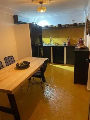 a kitchen with a wooden table and chairs in a room at Riad La Brune in Marrakech