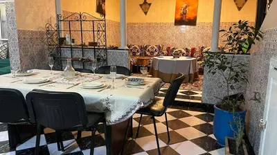 a dining room with a table and chairs in a restaurant at Riad Flouris in marrakech in Marrakech