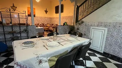 a table in a restaurant with a white table cloth at Riad Flouris in marrakech in Marrakech