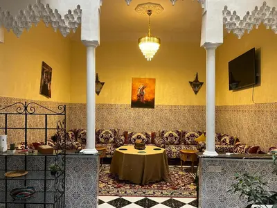 a room with couches and a table and a chandelier at Riad Flouris in marrakech in Marrakech