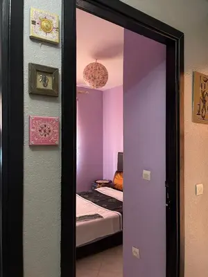 a door to a room with a bed and a mirror at Apparemment alhamra in Marrakech