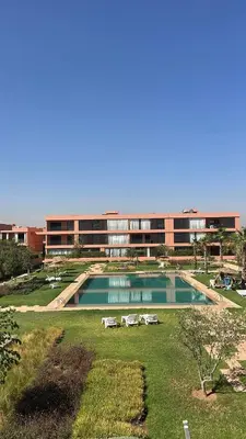 a large swimming pool in front of a building at Superbe appart 3p confort avec terrasse et vu piscin in Marrakech