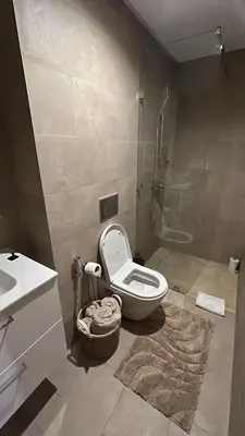 a bathroom with a toilet and a sink and a shower at Superbe appart 3p confort avec terrasse et vu piscin in Marrakech