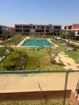 a large swimming pool in a large building at Superbe appart 3p confort avec terrasse et vu piscin in Marrakech