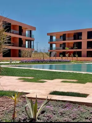 a swimming pool in front of a building at Superbe appart 3p confort avec terrasse et vu piscin in Marrakech