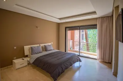 a bedroom with a bed and a large window at Gueliz carree Eden apartment in Marrakech