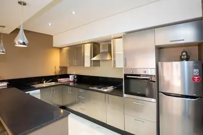 a kitchen with stainless steel appliances and black counter tops at Gueliz carree Eden apartment in Marrakech