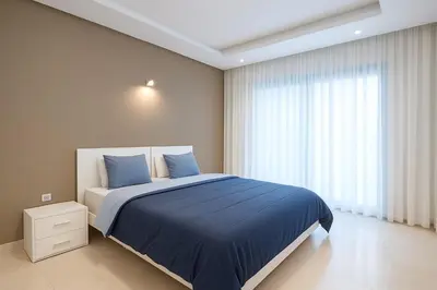 a bedroom with a bed with blue sheets and a window at Gueliz carree Eden apartment in Marrakech