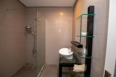 a bathroom with a sink and a glass shower at Gueliz carree Eden apartment in Marrakech