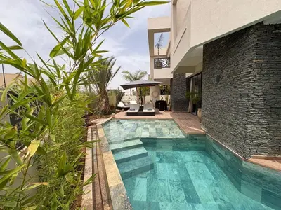 a swimming pool in front of a house at luxury 5 bedroom home in Marrakech