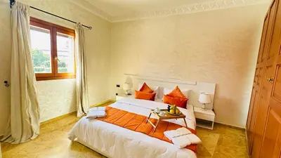 a bedroom with a large bed with orange pillows at Heart of Marrakech Chic & Central Gueliz Apartment - Free parking in Marrakech