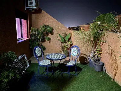 a patio with three chairs and a table and a table and chairs at Marrakech,Rouidate in Marrakech