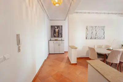 a white room with a table and a dining room at Charming Central 2 Bedroom Apartment with Pool Near Train Station in Marrakech
