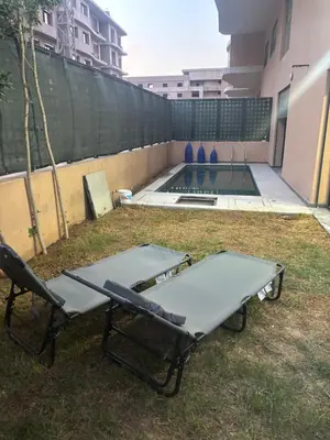 a ping pong table and two chairs in a backyard at Elite garden in Marrakech