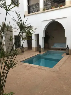 a swimming pool in the courtyard of a house at Oasis de la Médina -Piscine Chauffée - Climatisation Petit-Déjeuner et Gouvernante in Marrakech