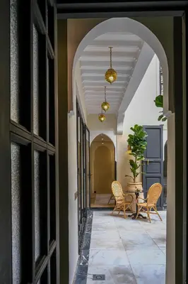 an archway leading into a hallway with chairs and a table at Riad Layl Marrakech a seulement 2 minutes à pied de la célèbre place Jemaa El Fna in Marrakech