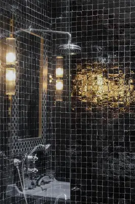a black tiled bathroom with a sink and a mirror at Riad Layl Marrakech a seulement 2 minutes à pied de la célèbre place Jemaa El Fna in Marrakech