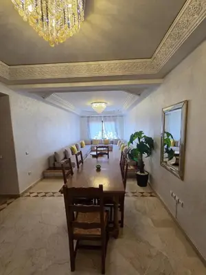 a dining room with a table and chairs and a chandelier at andlous 4 in Marrakech