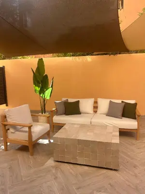 a living room with couches and a table and a plant at Appartement chic Menara Mall piscine Rooftop in Marrakech