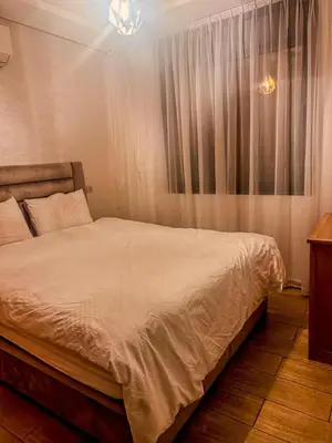 a bedroom with a white bed with a window at דירה