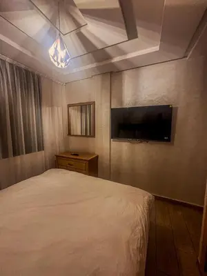 a bedroom with a bed and a flat screen tv at דירה