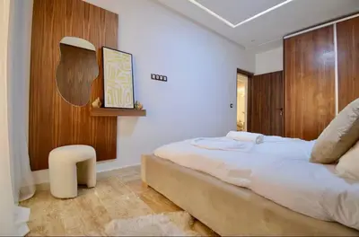 a bedroom with a large bed and a wooden wall at Elegant Luxury Apartment in Marrakech