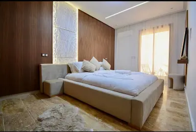 a large white bed in a room with a large window at Elegant Luxury Apartment in Marrakech