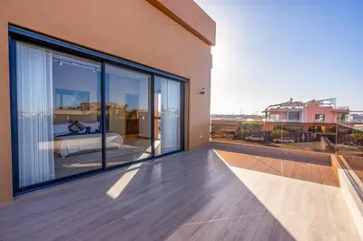 a balcony of a house with large glass windows at Villa Santa Marrakech in Marrakech