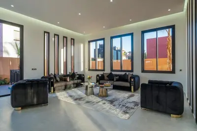 a living room with couches and chairs and windows at Villa Santa Marrakech in Marrakech