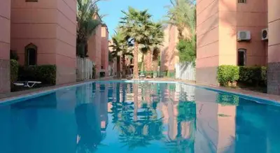 a swimming pool in a building with blue water at Riad-style triplex in secure residence in Marrakech