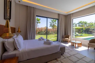 a bedroom with a large bed and a large window at Villa Jamila Marrakech in Segraga