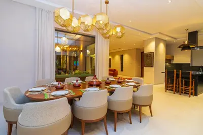 a dining room with a wooden table and chairs at Villa Jamila Marrakech in Segraga