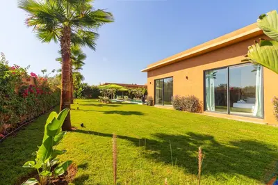 a house with a palm tree in a yard at Villa Jamila Marrakech in Segraga