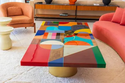 a colorful coffee table in a living room with two chairs at Villa Jamila Marrakech in Segraga