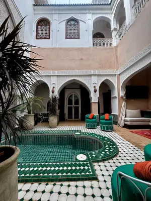 a courtyard with a golf course in the middle of a building at riad les cinq terres in Marrakech