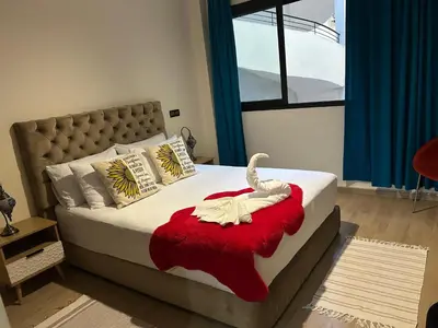 a bedroom with a bed with a swan on a red blanket at Guéliz Horizon - Central Apartment in Miramas2 in Marrakech