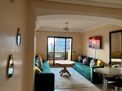 a living room with a green couch and a table at Guéliz Horizon - Central Apartment in Miramas2 in Marrakech