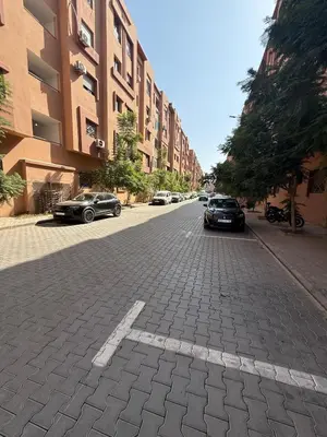 an empty street with cars parked on the side of a building at A24 Confortable Moderne Au Centre-ville in Marrakech