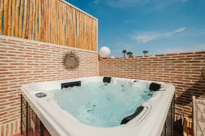 a jacuzzi tub in a brick building at Riad Les Sultanes Havre de paix avec jacuzzi prive in Marrakech