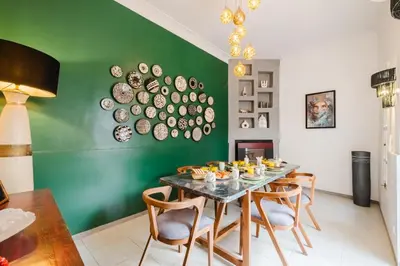 a dining room with a table and a green wall at Riad Les Sultanes Havre de paix avec jacuzzi prive in Marrakech