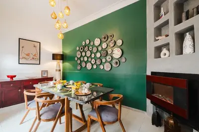 a dining room with a table and chairs and a green wall at Riad Les Sultanes Havre de paix avec jacuzzi prive in Marrakech